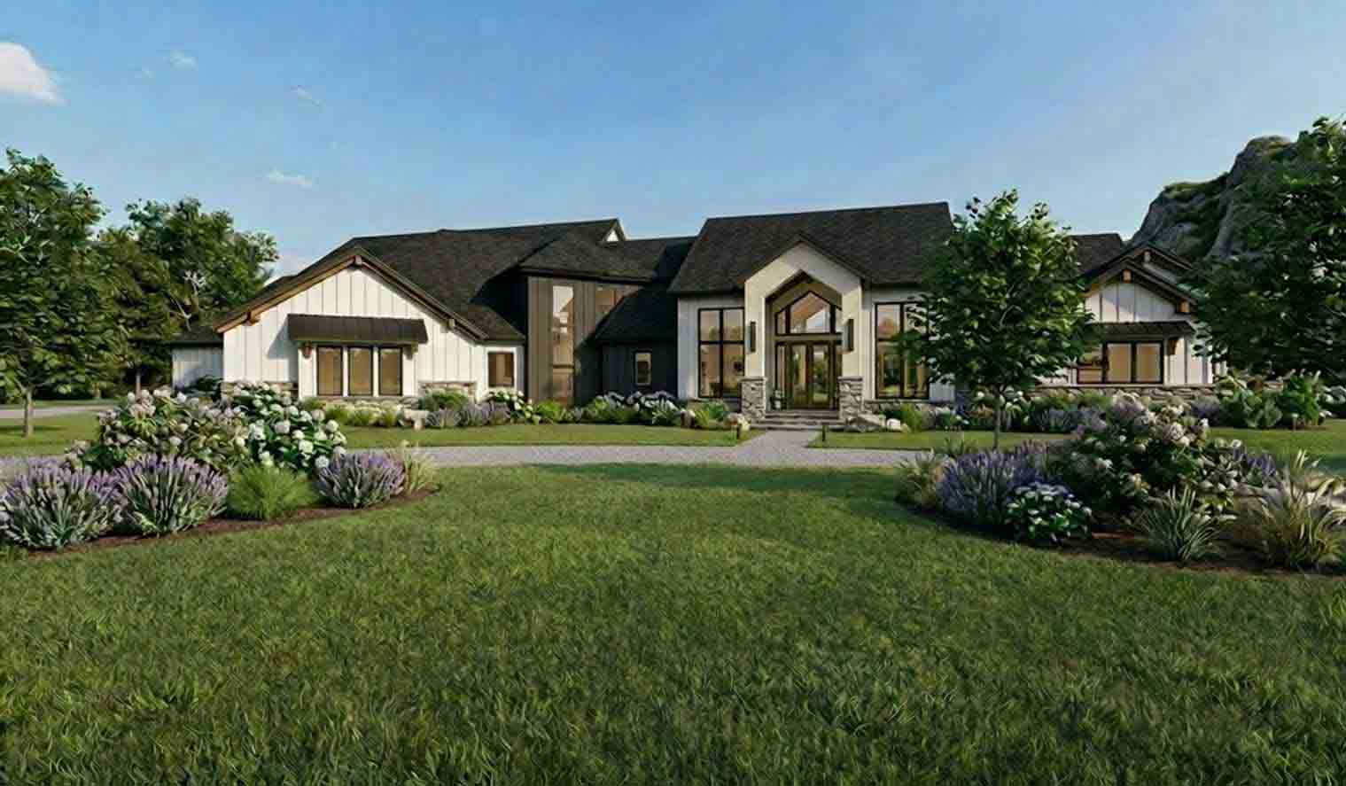 Bright modern farmhouse-style home with white siding, dark metal roof accents, stone foundation, large arched entry, and lush professional landscaping